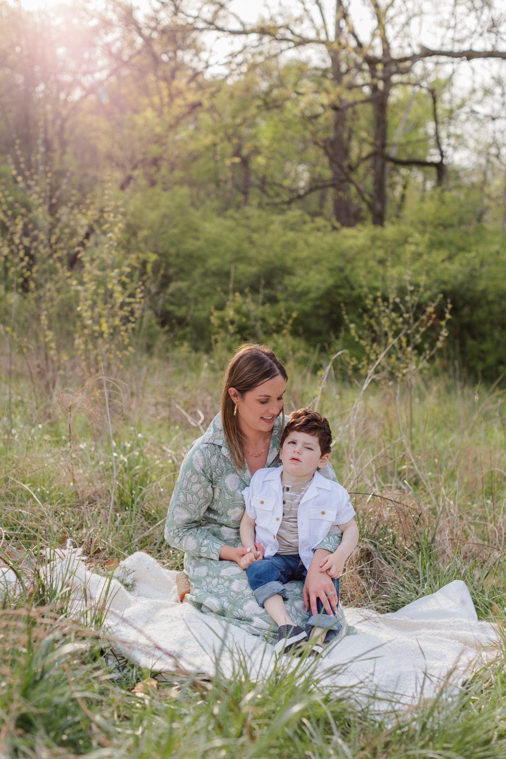 mother sitting with young son during outdoor family session in field - St Louis family photographer