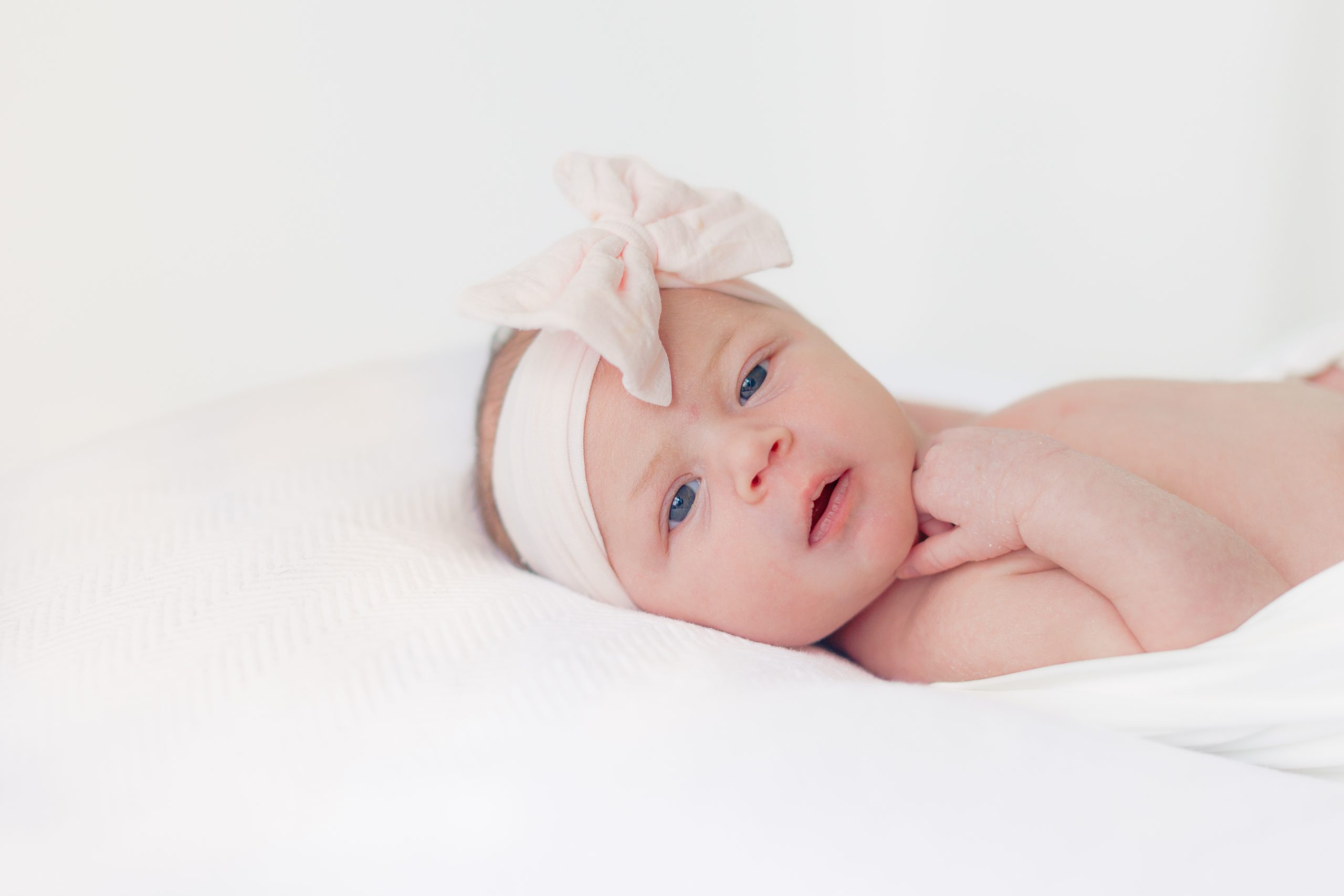 newborn baby girl wearing bow headband - St Louis newborn photographer
