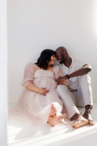 expecting parents sitting together during studio maternity session - St Louis maternity photographer